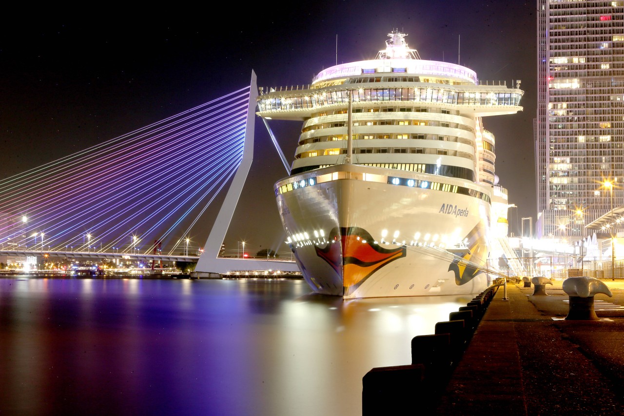 Die „Aida Perla“ liegt am nächtlichen Hafen von Rotterdam. 