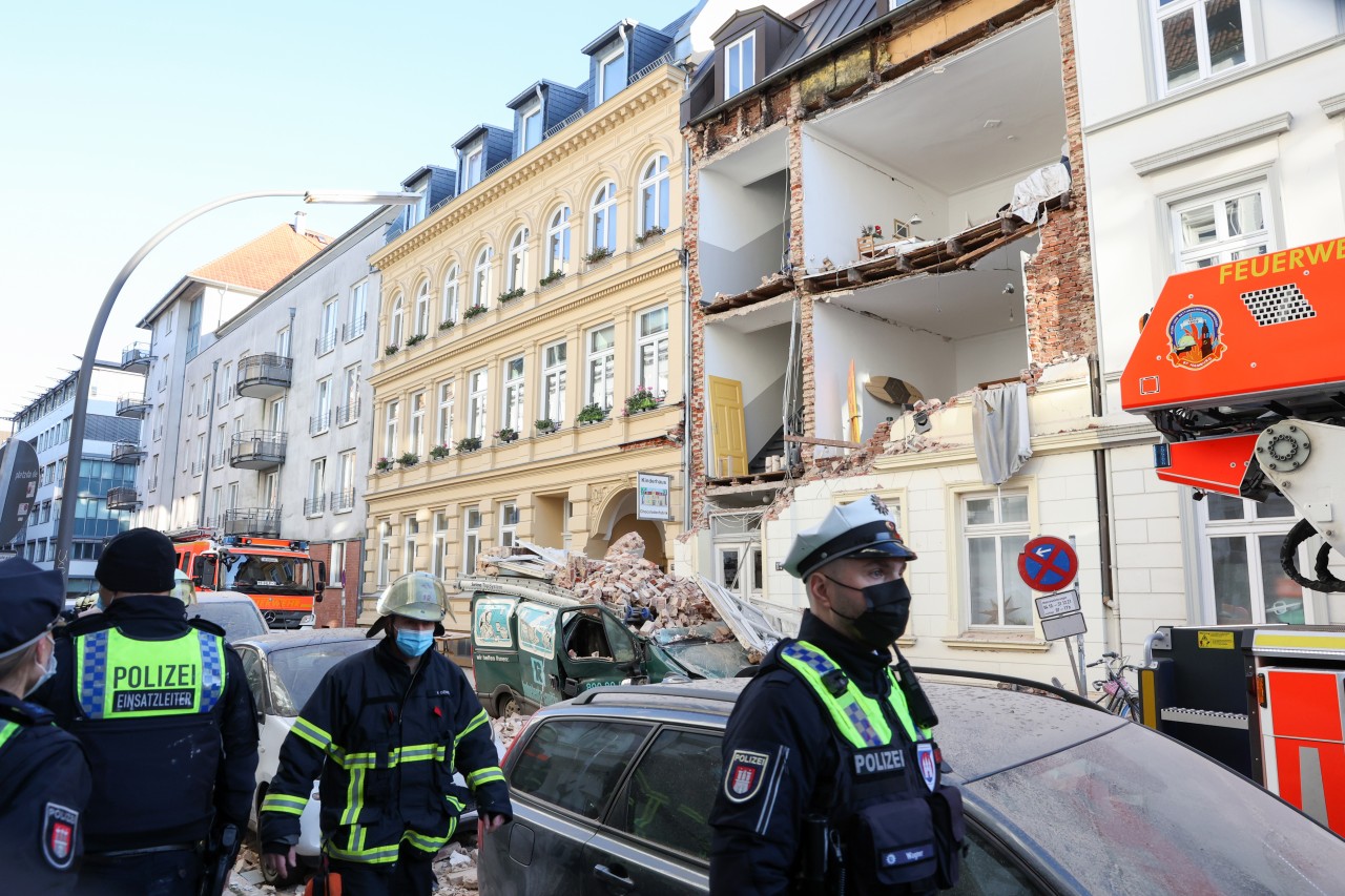Hamburg: Einsatzkräfte stehen vor einem Haus, dessen Fassade eingestürzt ist. 