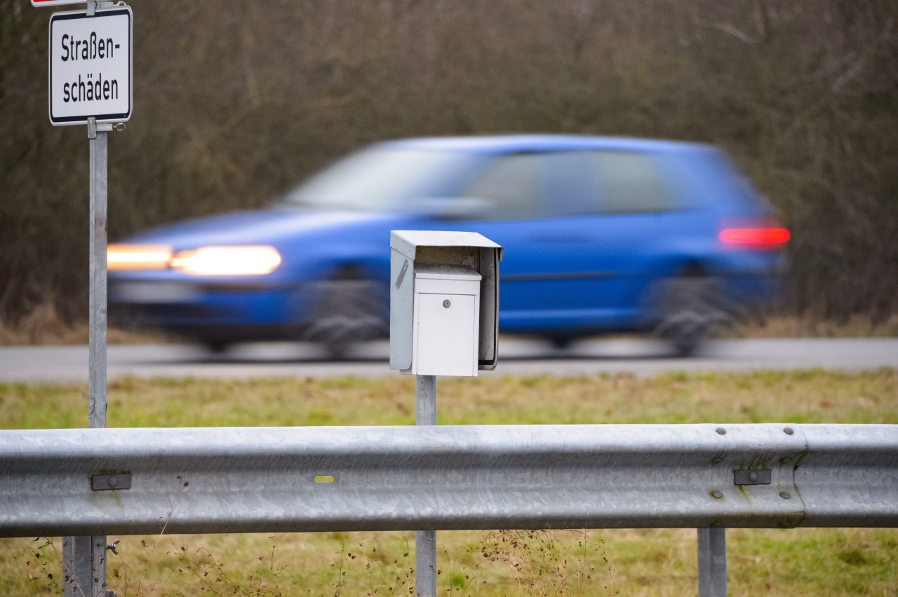 Ein weißer Briefkasten steht zwischen vorbeifahrenden Autos auf dem Mittelstreifen der A20 bei Bad Segeberg.