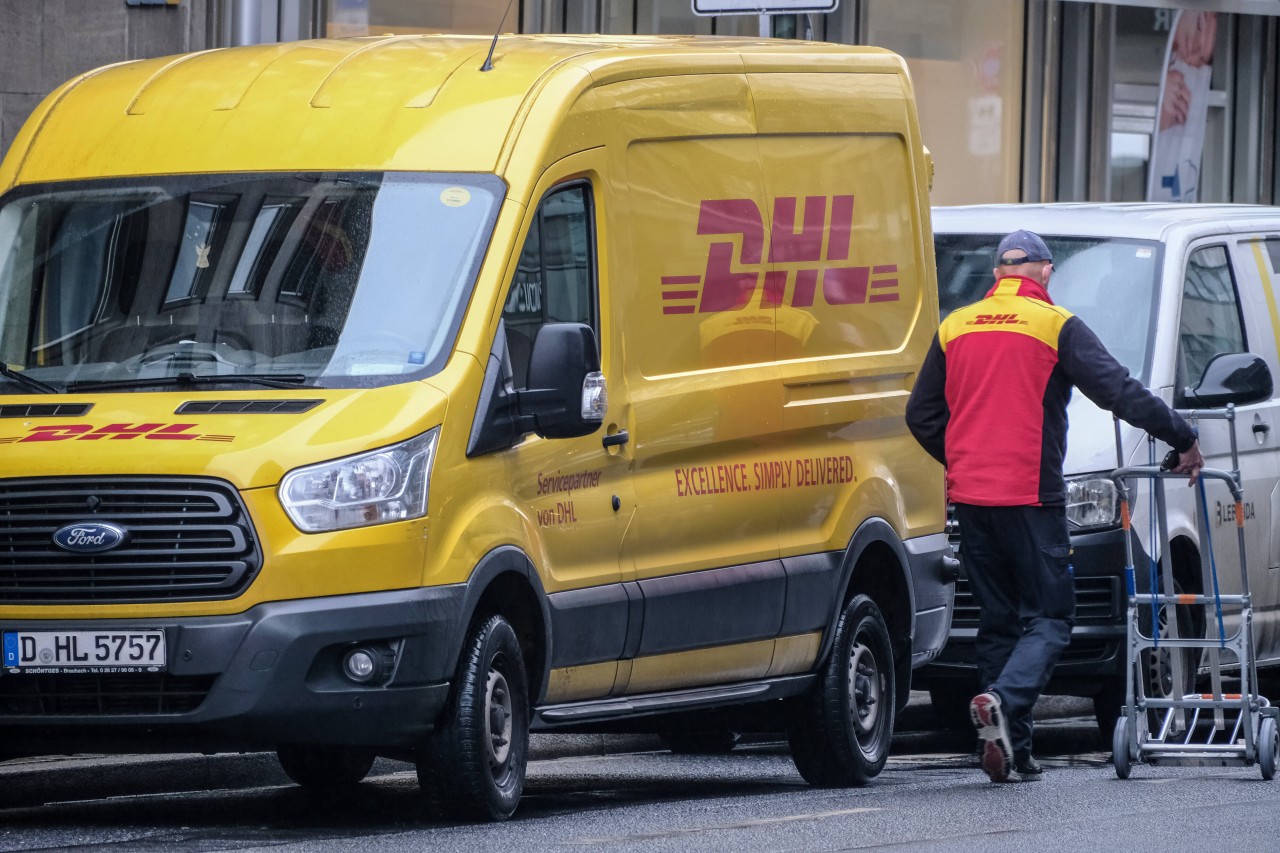 Ein DHL-Paketbote bei der Zustellung (Symbolfoto).