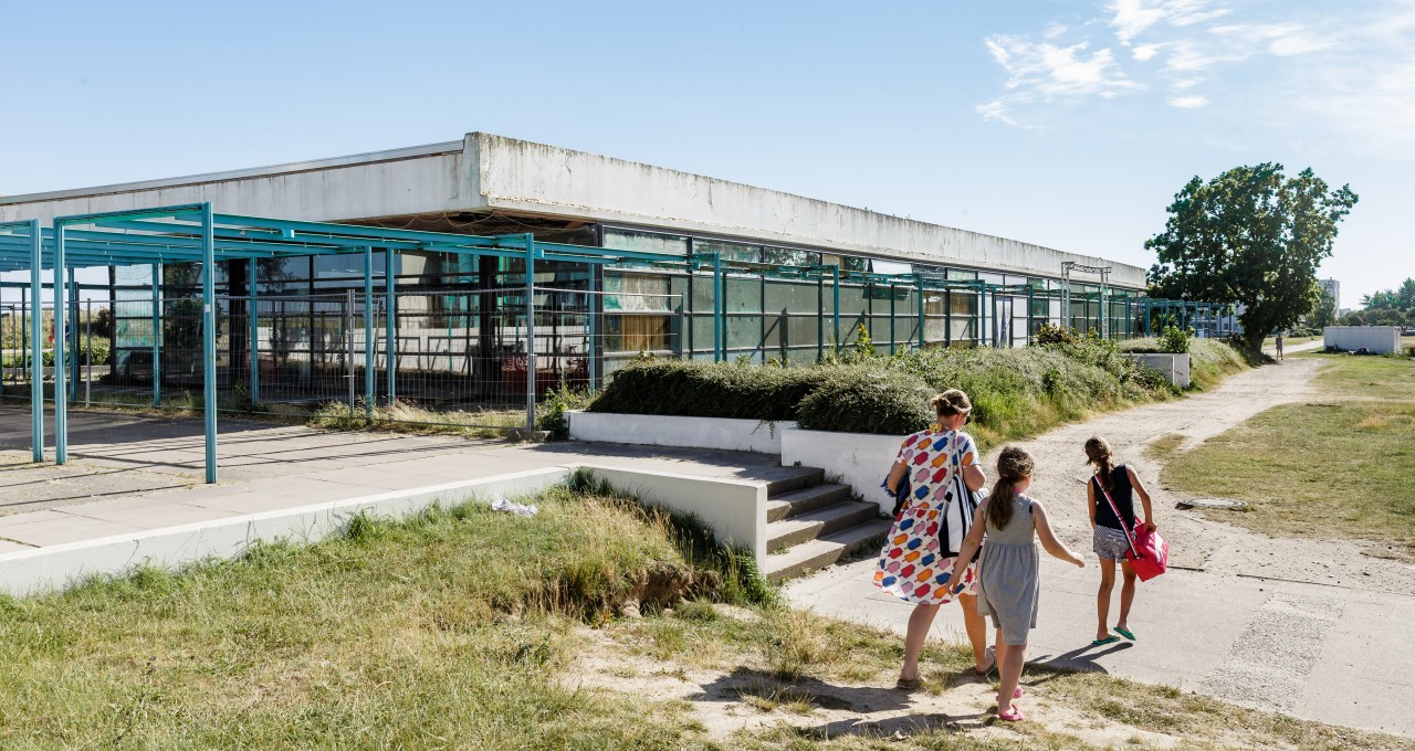 Fehmarn: Eine Familie geht im Sommer am leerstehenden Haus des Gastes des dänischen Architekten Arne Jacobsen vorbei.