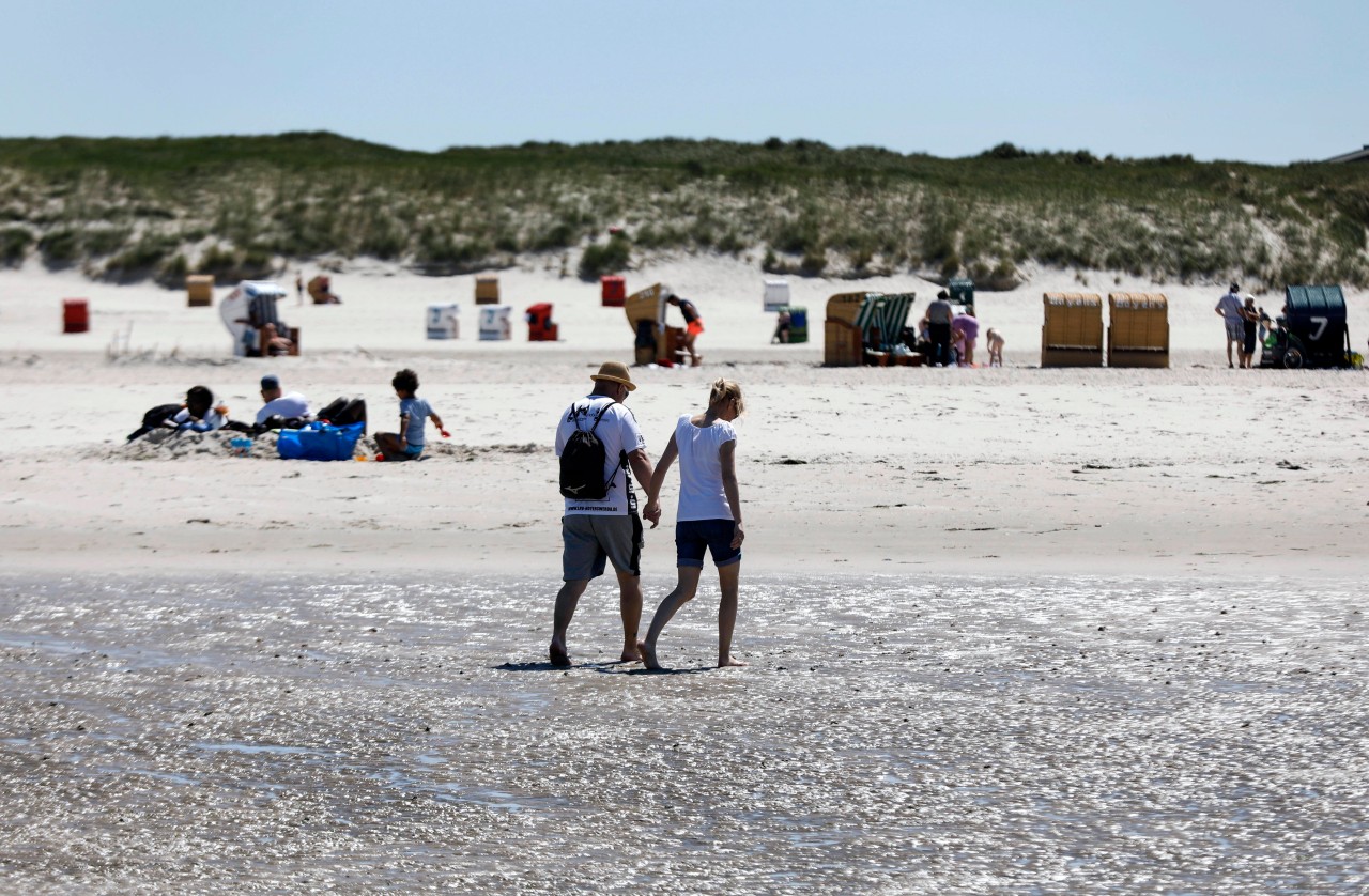 Ferien: Urlauber spazieren auf Amrum in der Nordsee.