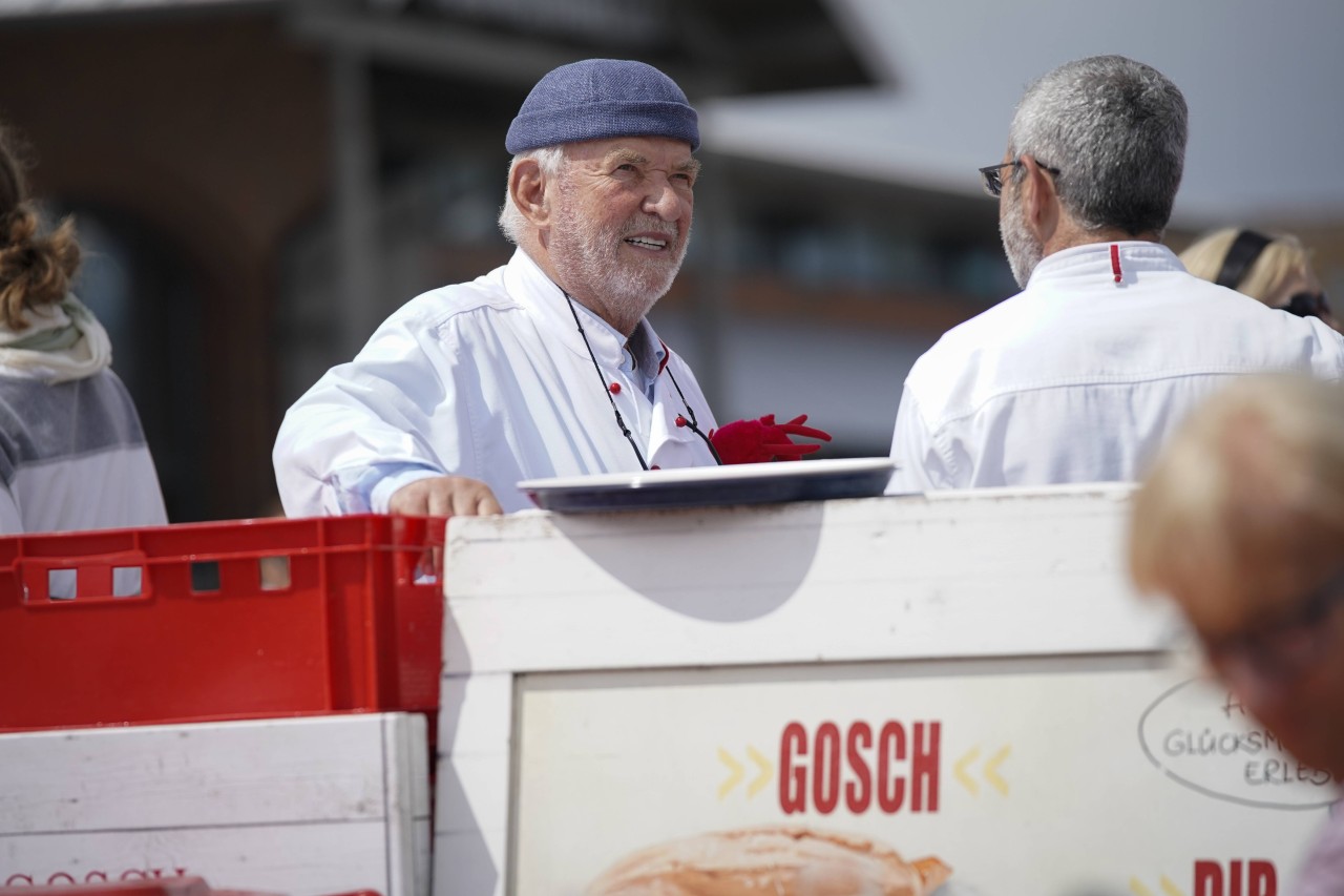 Jürgen Gosch erfolgreicher Inhaber, Unternehmer, Fischhänder und Visionär der gleichnamigen Marke Gosch an seinem Standort auf Sylt List in Kochjacke mit Firmenlogo.