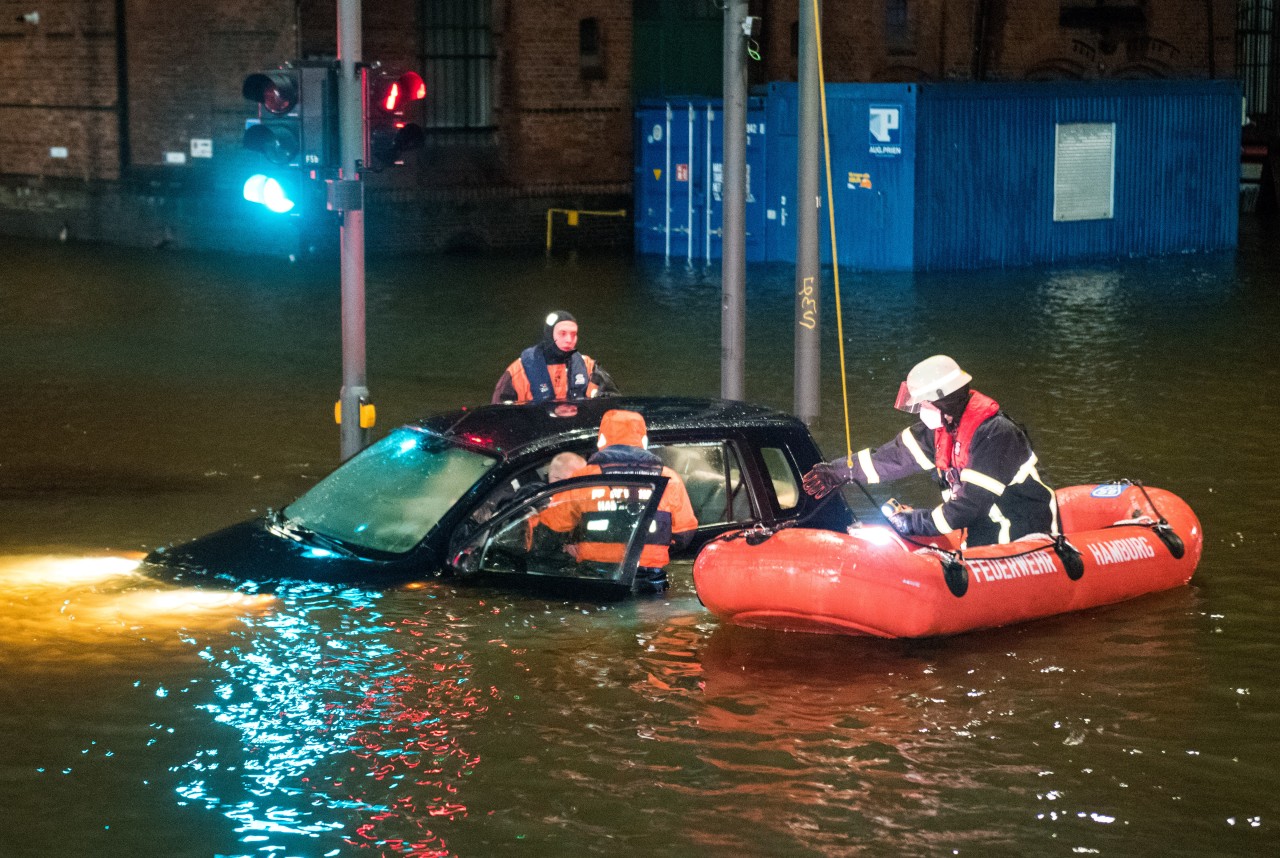 Feuerwehrleute retten in der Speicherstadt während einer Sturmflut beim Hochwasser der Elbe einen Mann aus seinem Auto, der zuvor versehentlich in das Wasser gefahren war.