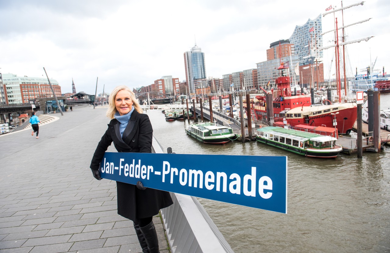 Maion Fedder mit dem Schild für die Jan-Fedder-Promenade