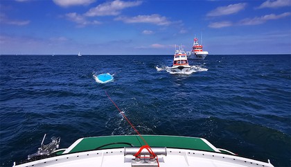 Das umgekippte Segelboot vor Lübeck-Travemünde, daneben die Schiffe der DGzRS.