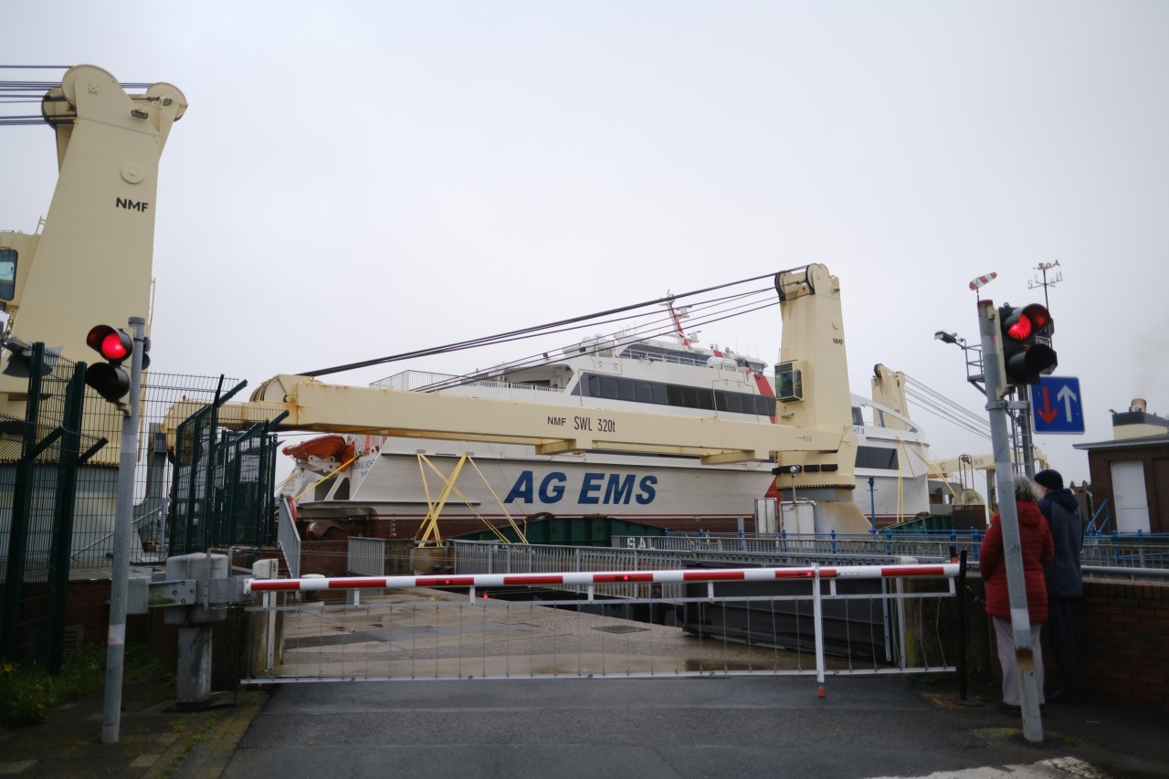 Die MS Paula fährt auf der Ems bei Emden und hat dabei den neuen Katamaran Nordlicht II für die AG Ems huckepack geladen.