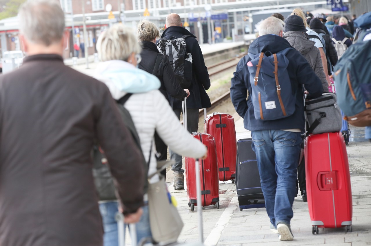 Reisende kommen am Pfingstwochenende mit Gepäck am Bahnhof Westerland auf Sylt an