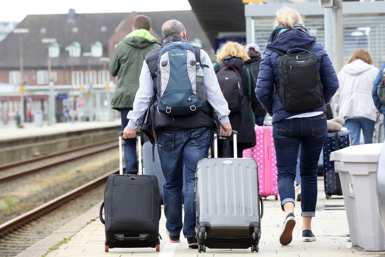 Reisende kommen mit Gepäck am Bahnhof Westerland auf Sylt an.