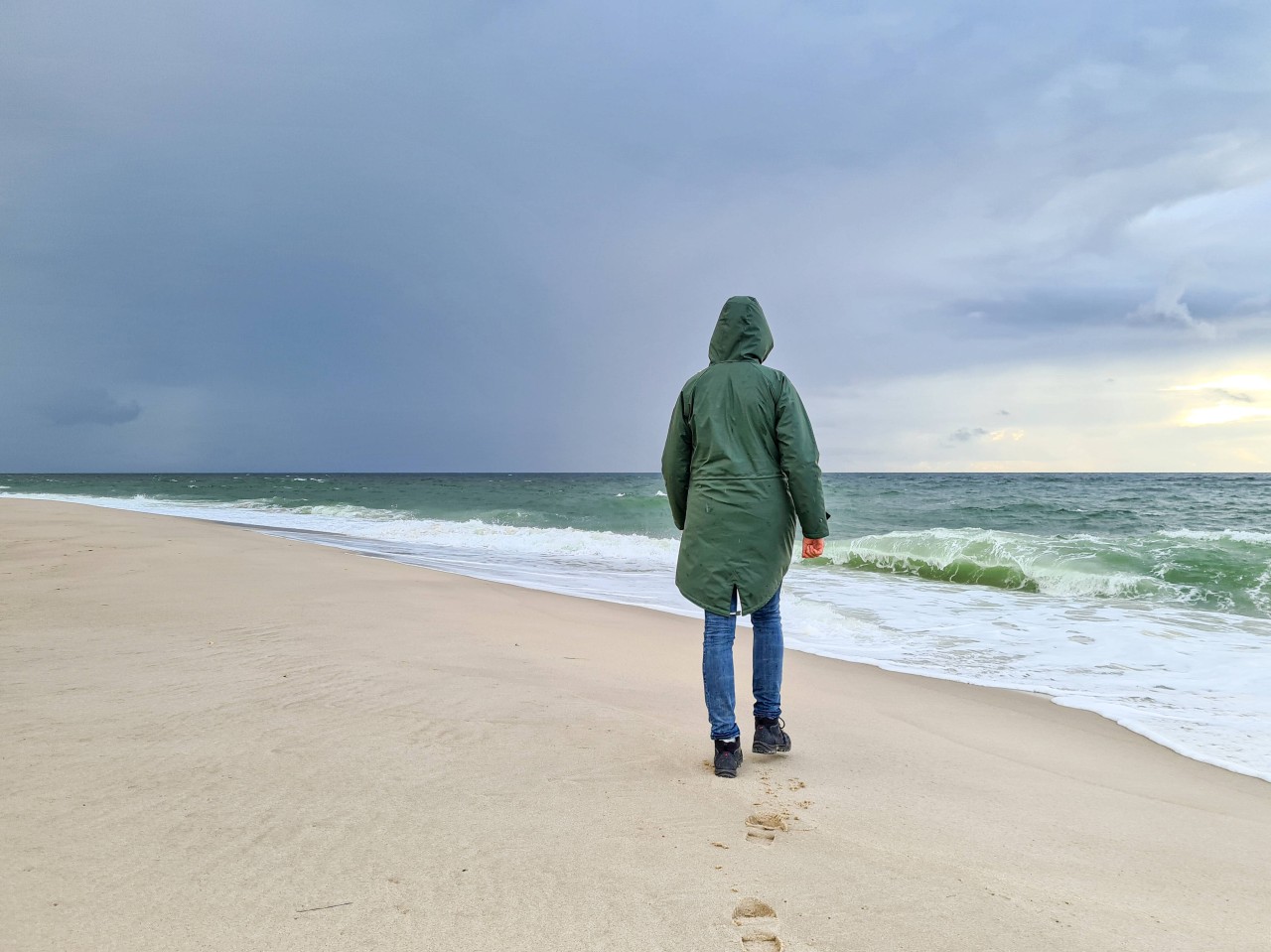 Eine Spaziergängerin am Strand von Sylt.