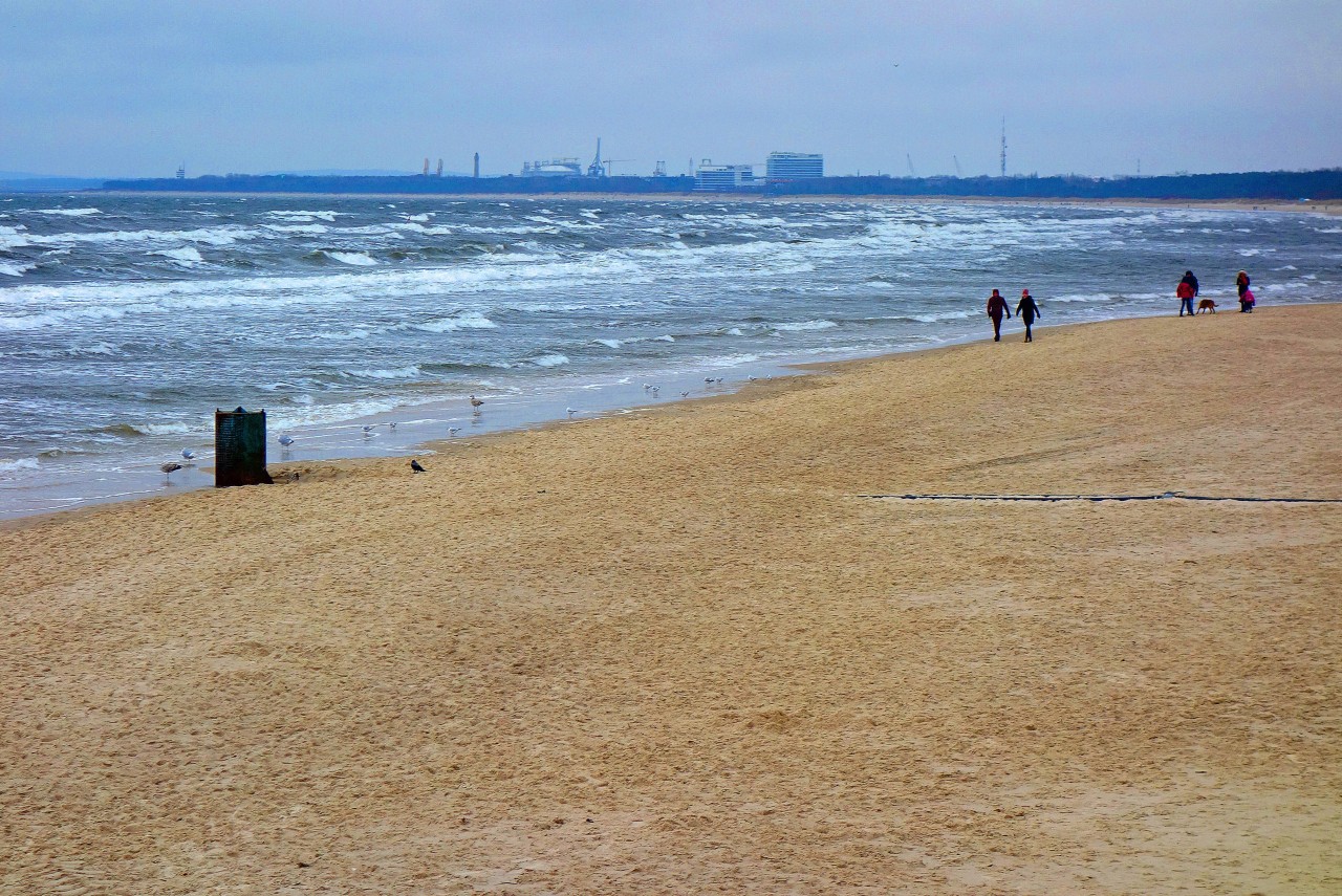 Menschen bei windigem Wetter am Strand von Usedom.