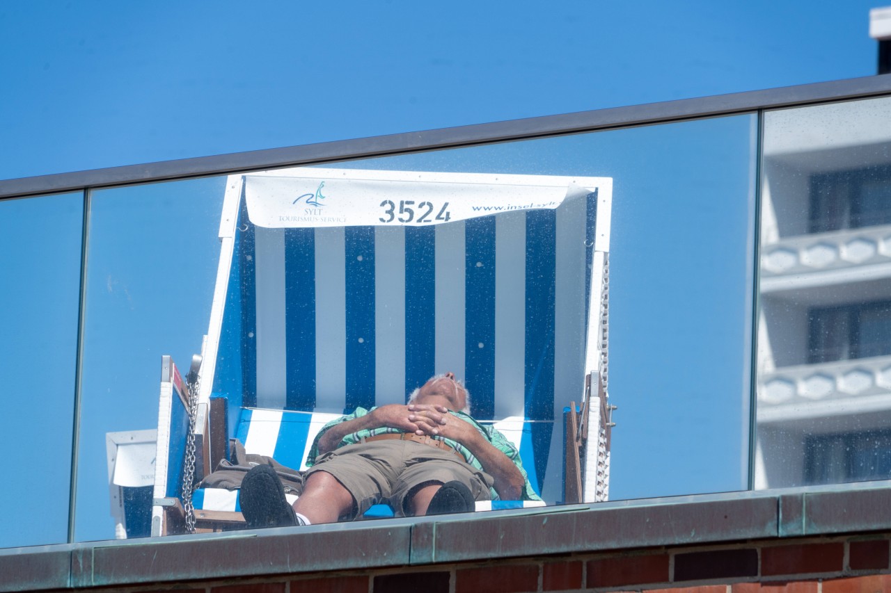 Ein Mann sonnt sich am Strand von Westerland auf Sylt