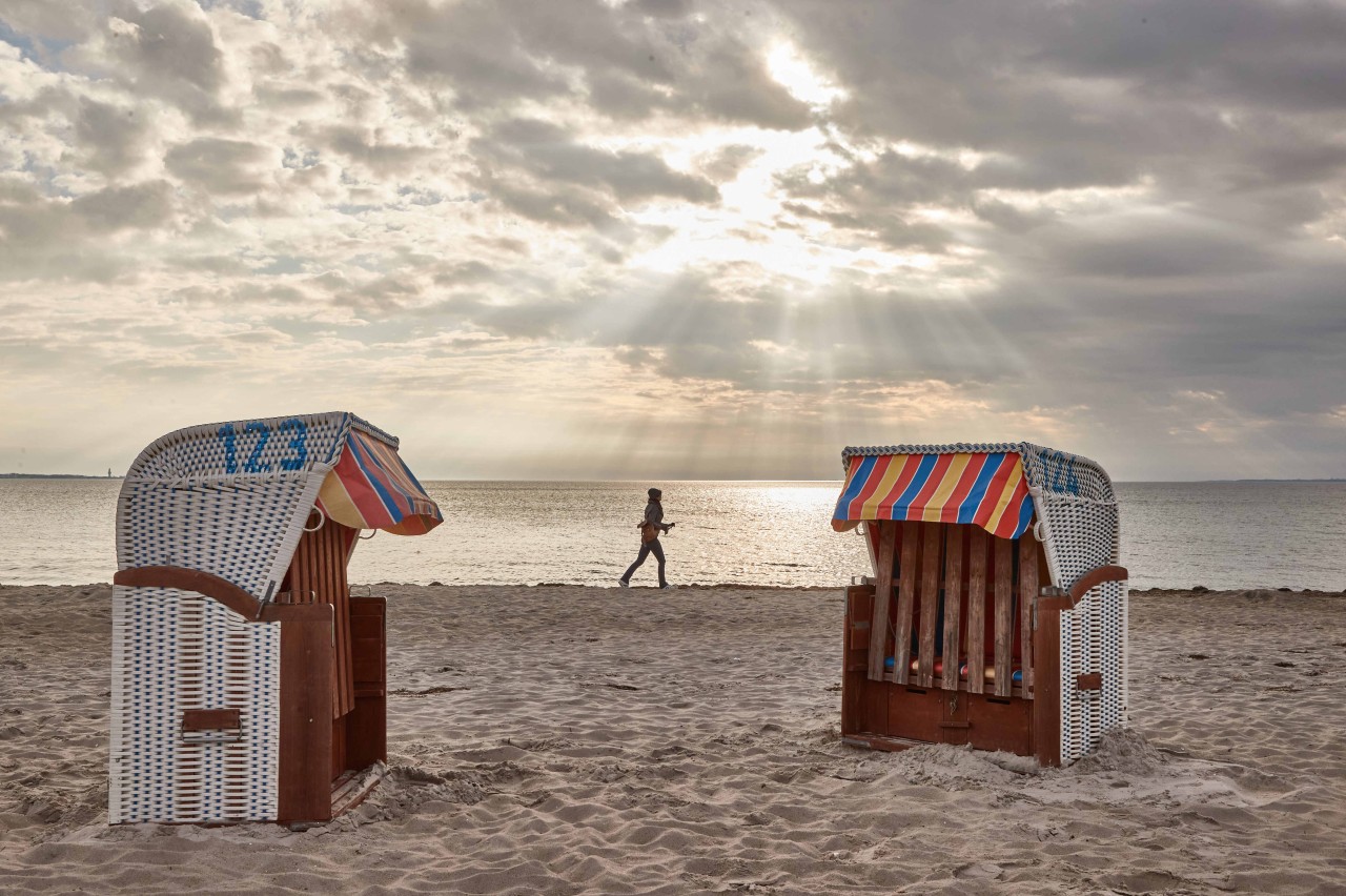 Eine Frau joggt am Strand von Scharbeutz entlang.