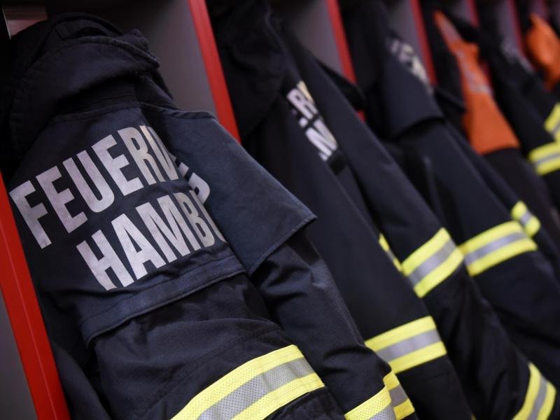 Feuerwehr-Einsatzjacken hängen in einer Feuerwache in Hamburg.
