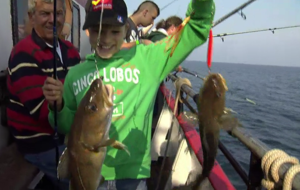 Stolz hält der junge Angler seinen Fang in die Kamera. 