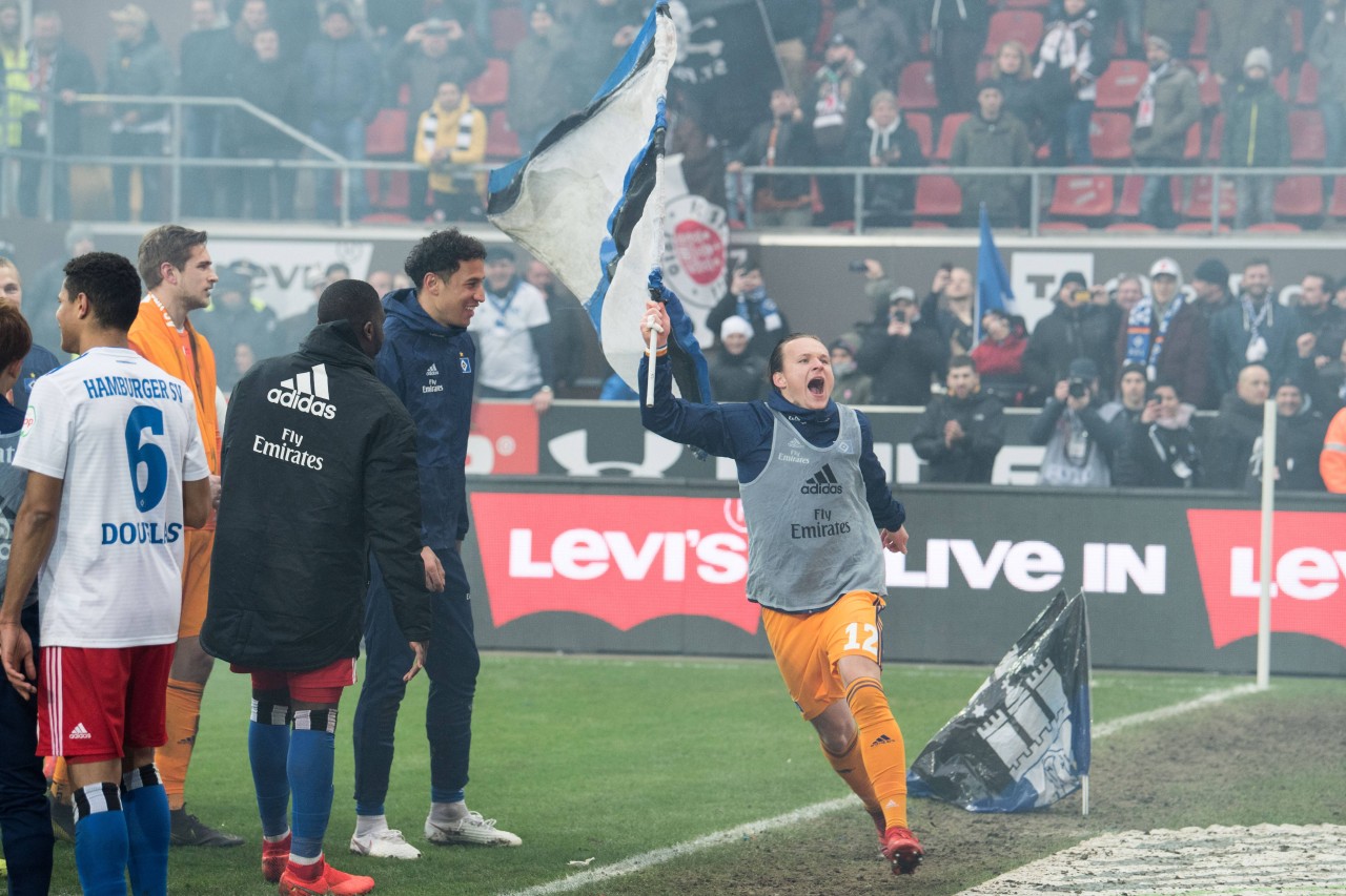 HSV-Torwart Tom Mickel jubelt mit einer Fahne vor dem Gästeblock am Millerntor.