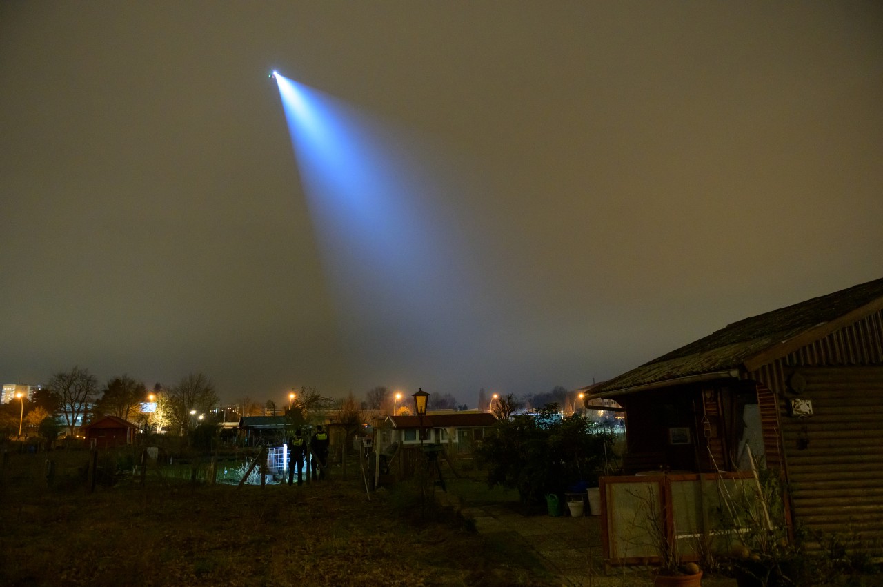 Der Polizei-Helikopter leuchtet mit seinem Suchscheinwerfer in einen Kleingartenverein in Hamburg.