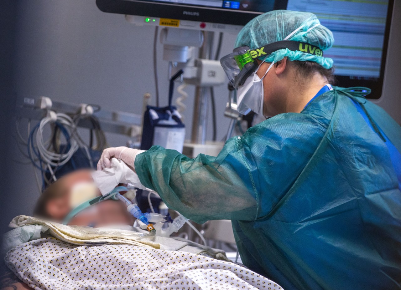 Eine Intensivschwester betreut einen Patienten in einem der Behandlungszimmer der Intensivstation in der Universitätsmedizin Rostock.