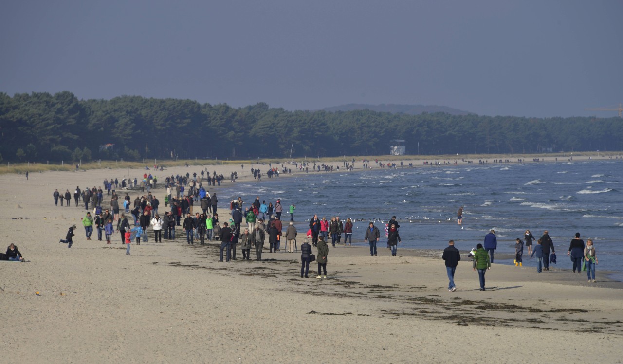 Spaziergänger am Strand von Rügen.