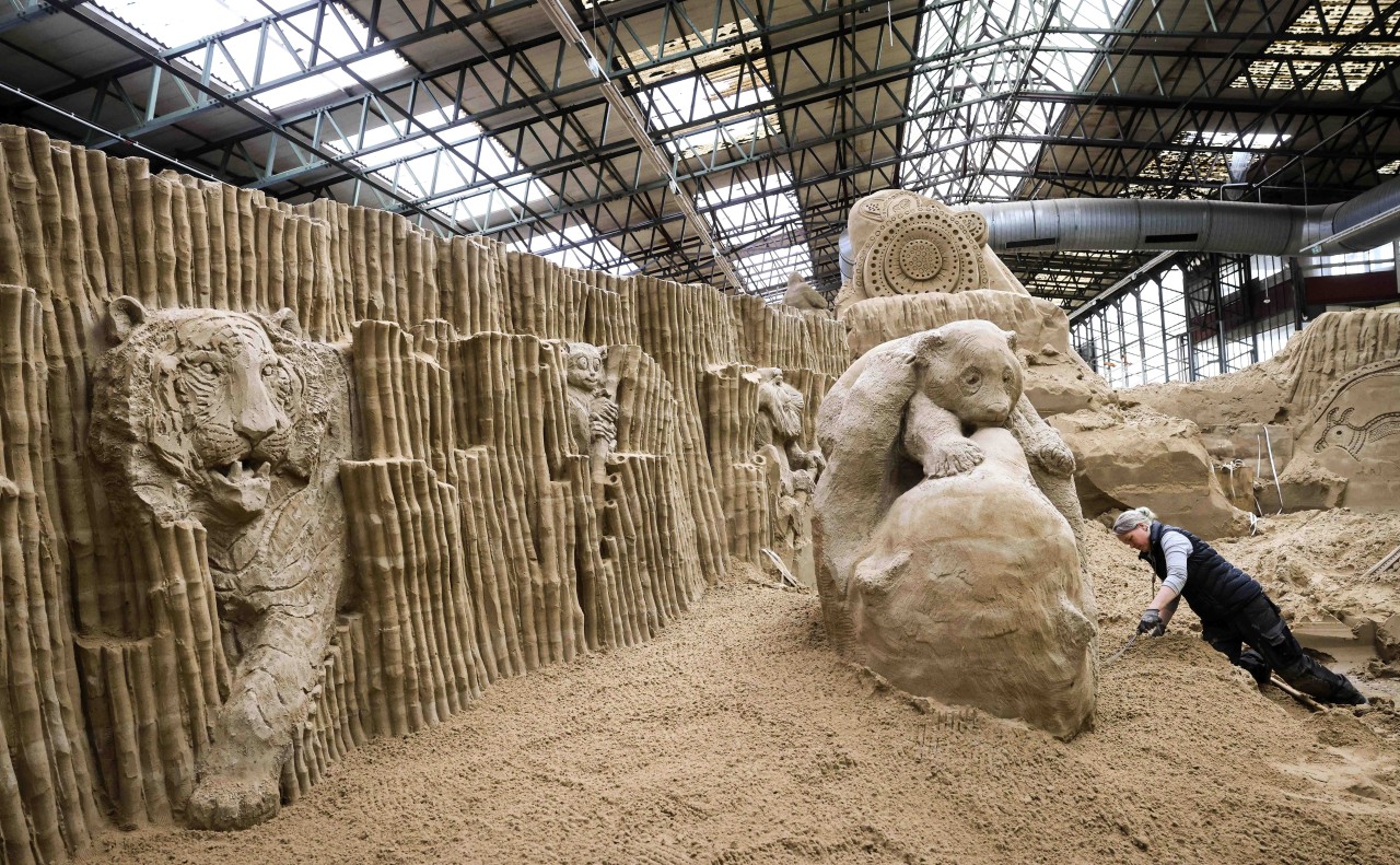 Eine Sandkünstlerin arbeitet an ihren Skulpturen