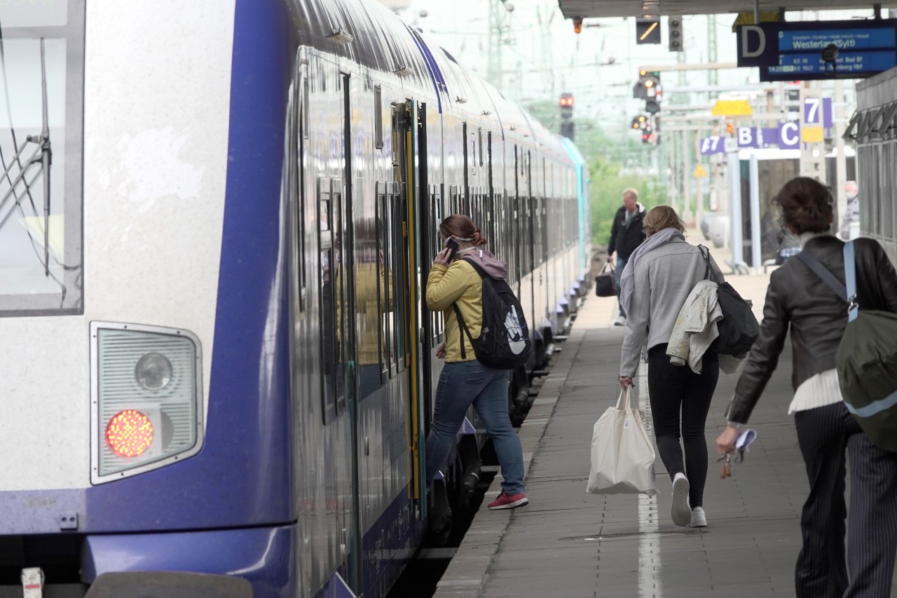 Reisende steigen in einen Regional-Express (RE 6) der Deutschen Bahn von Hamburg nach Sylt.