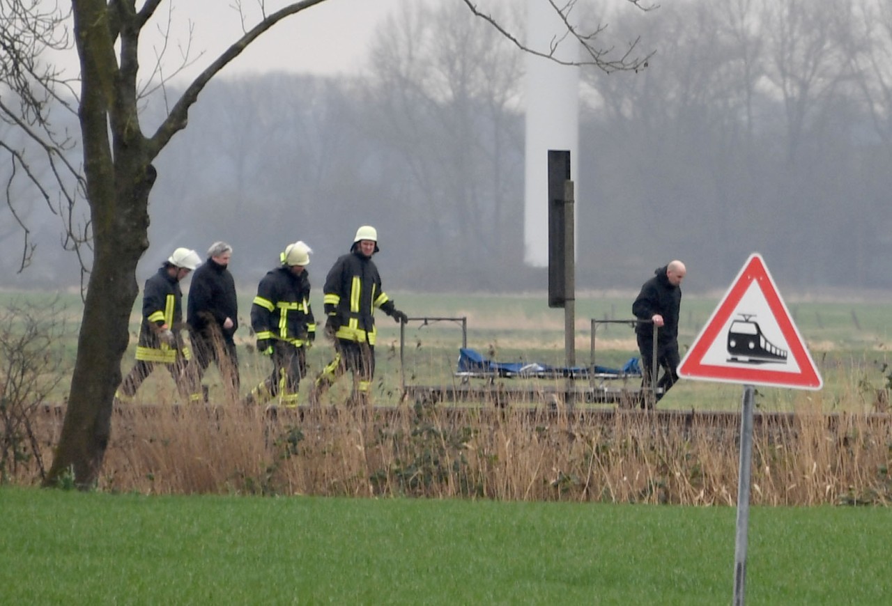 Feuerwehrmänner stehen an der Unglückstelle auf der Bahnstrecke Hamburg-Sylt nahe Wilster. 