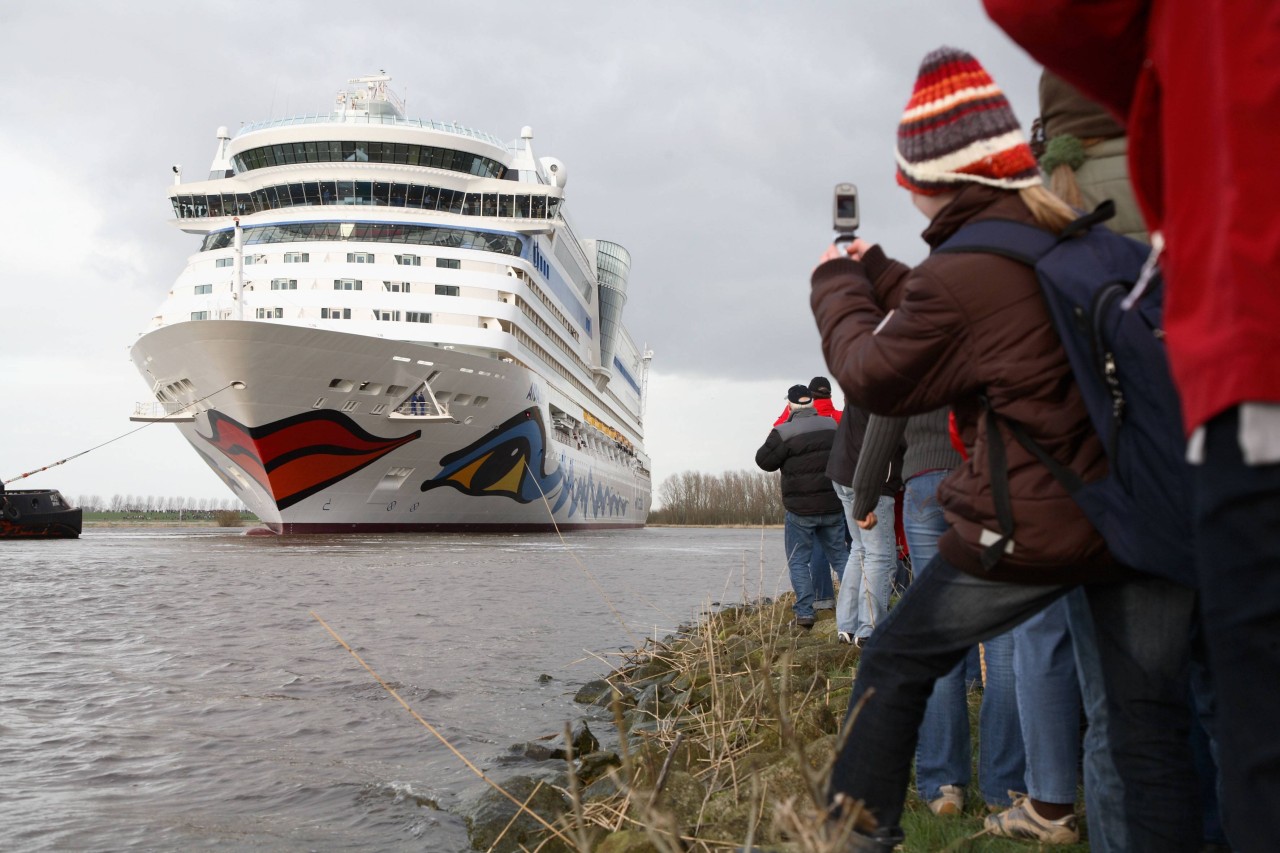 Die „Aida Diva“ verlässt 2007 die Meyer Werft in Papenburg. Rechts fotografiert ein Mädchen mit Klapphandy das Schiff.
