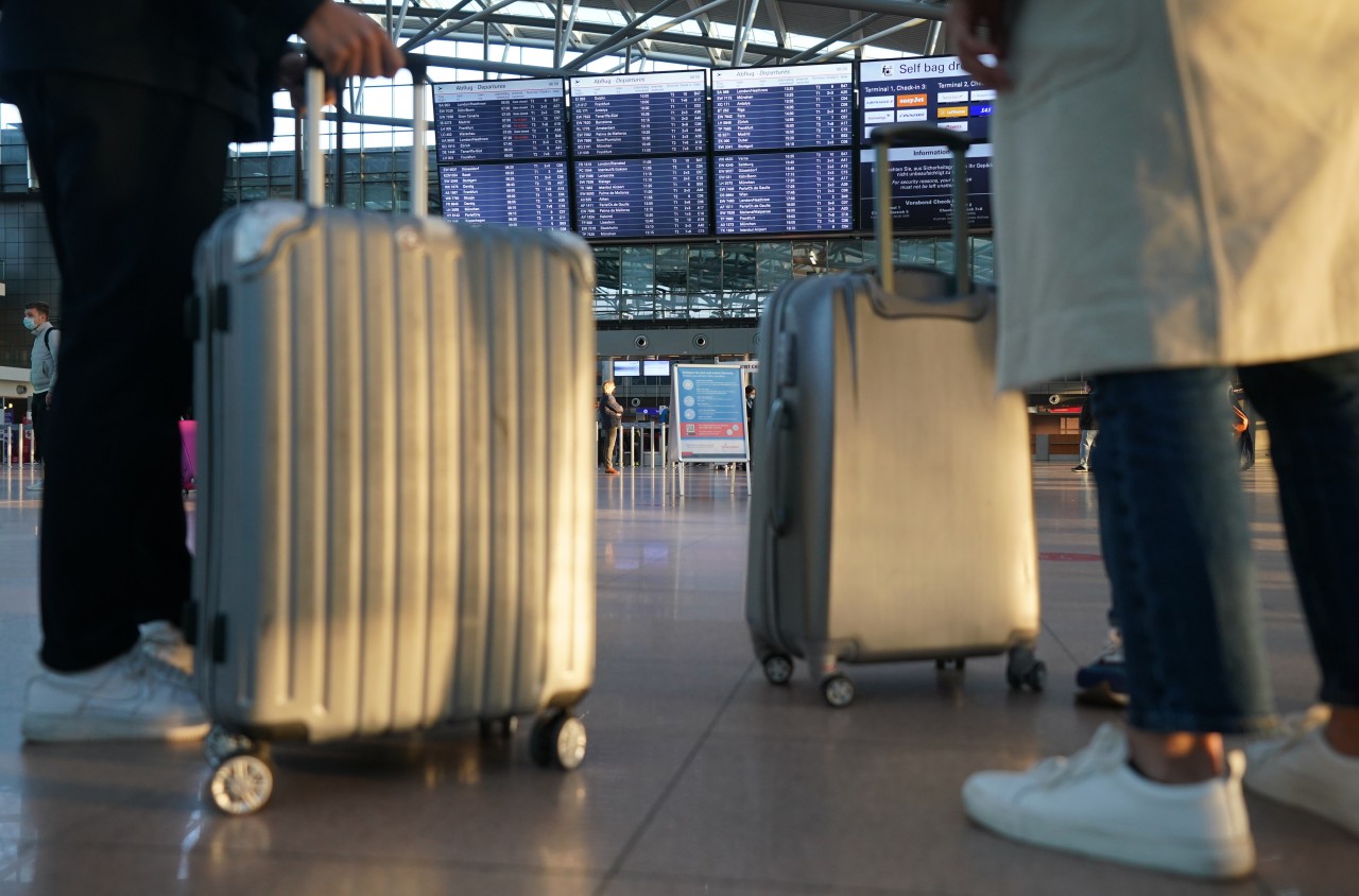 Passagiere stehen mit ihrem Gepäck im Terminal eins am Hamburg Flughafen.
