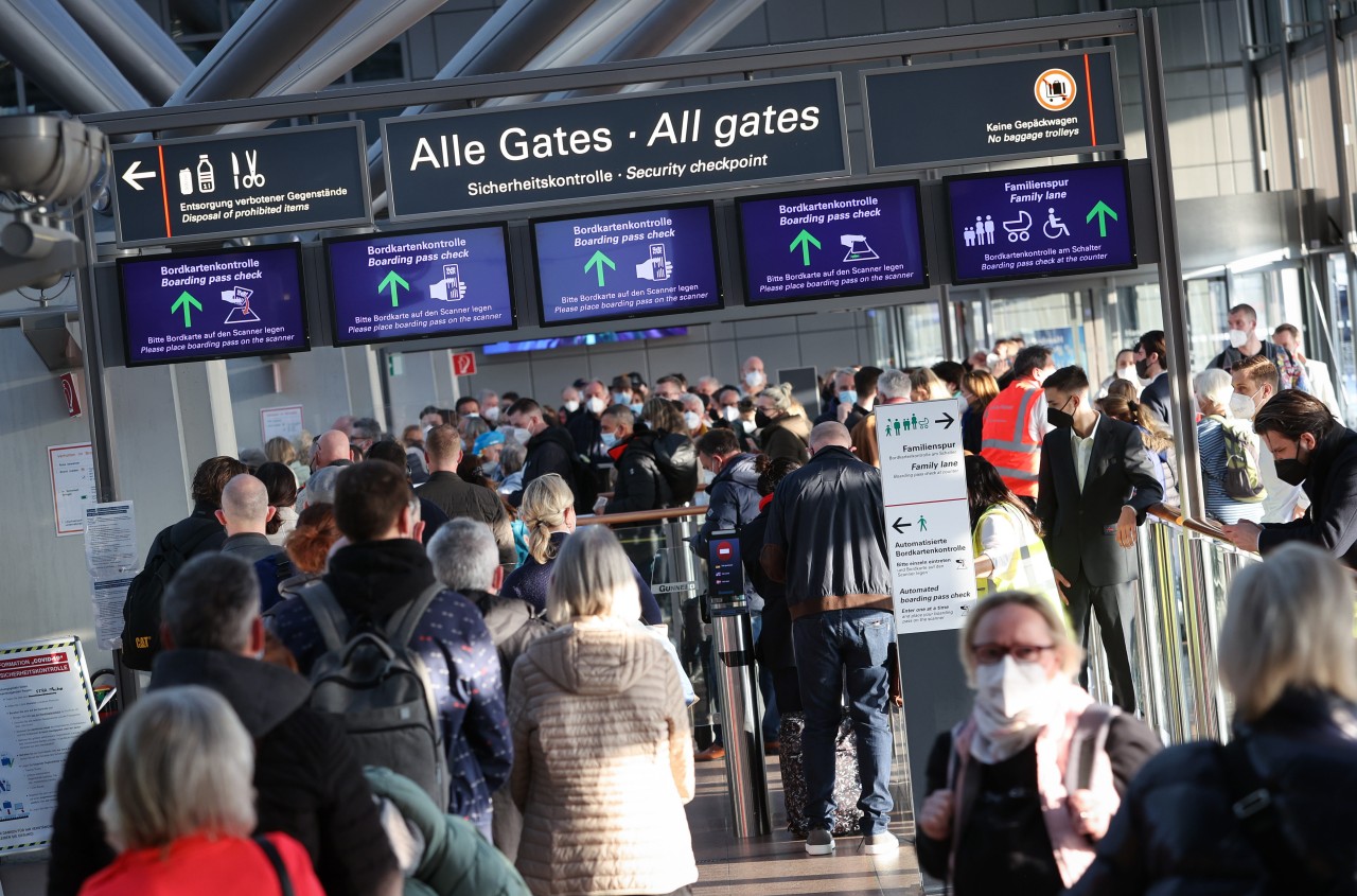 Reisende stehen in einer langen Schlange vor der Sicherheitskontrolle am Flughafen Hamburg. 