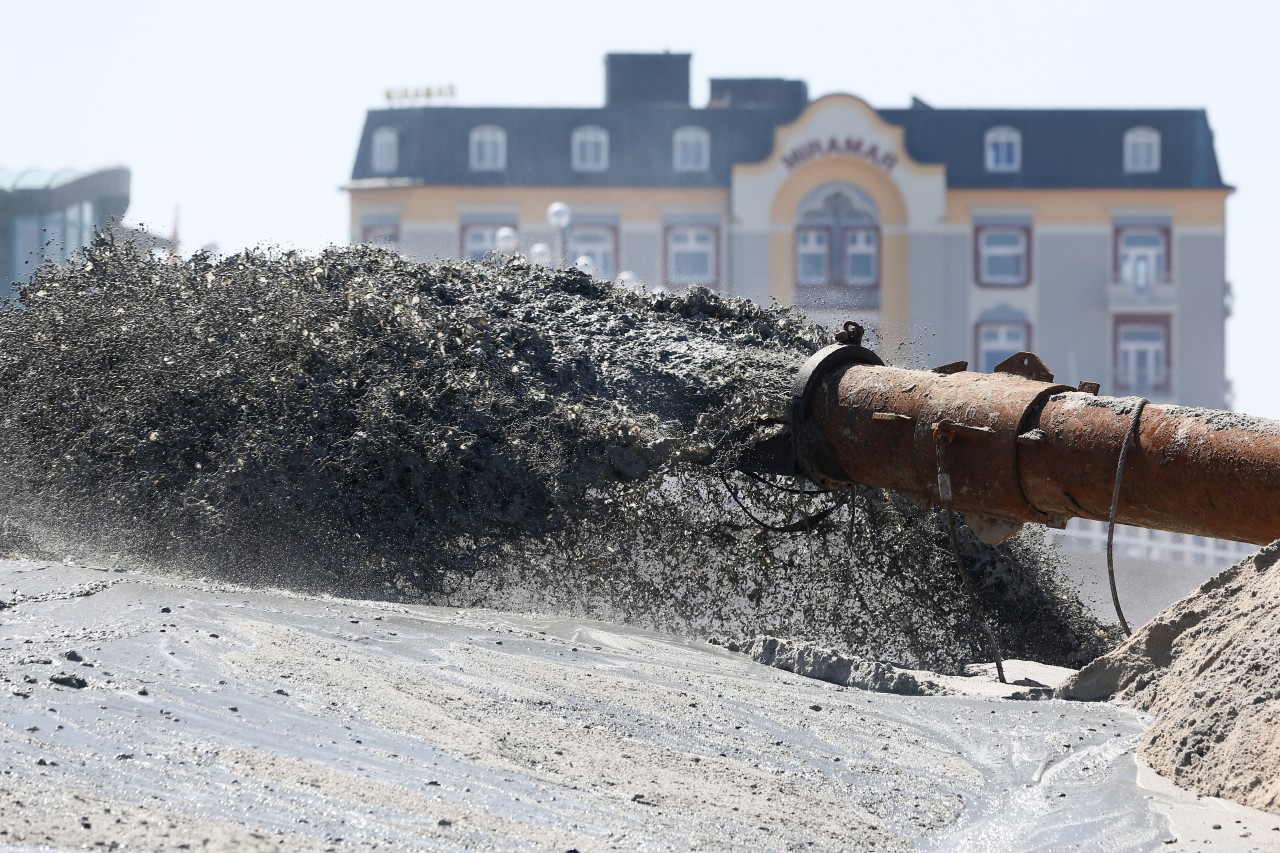 Mittels einer sogenannten Dükerleitung wird in Westerland auf Sylt ein Wasser-Sand-Gemisch von einem Spülschiff auf den Strand gespült (Archivfoto). 