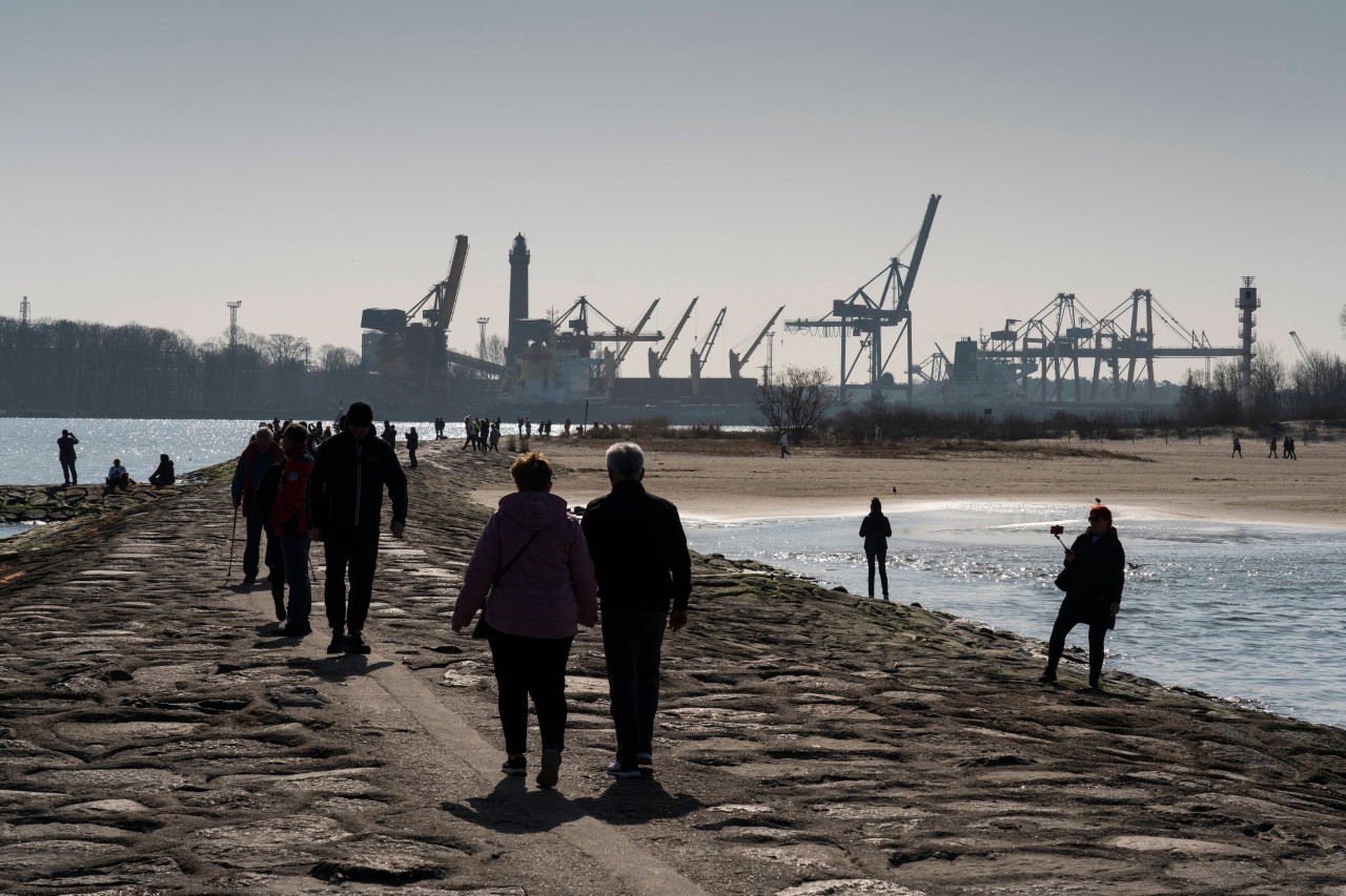 Touristen auf der Westmole an der Hafeneinfahrt in Swinoujscie (Swinemünde) auf der Ostsee-Insel Usedom in der Woiwodschaft Westpommern in Polen.