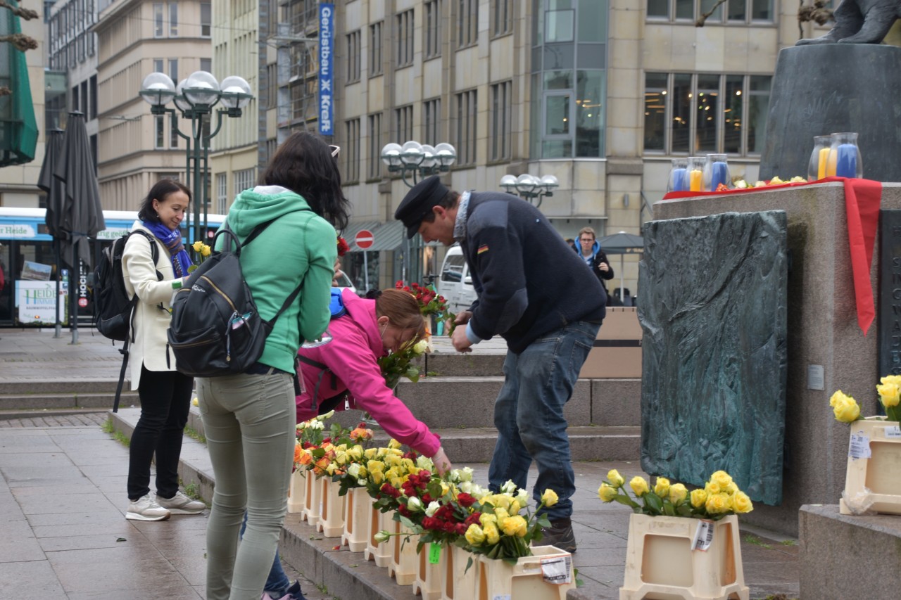 Menschen freuen sich über die Gratis-Rosen vor dem Rathaus in Hamburg.