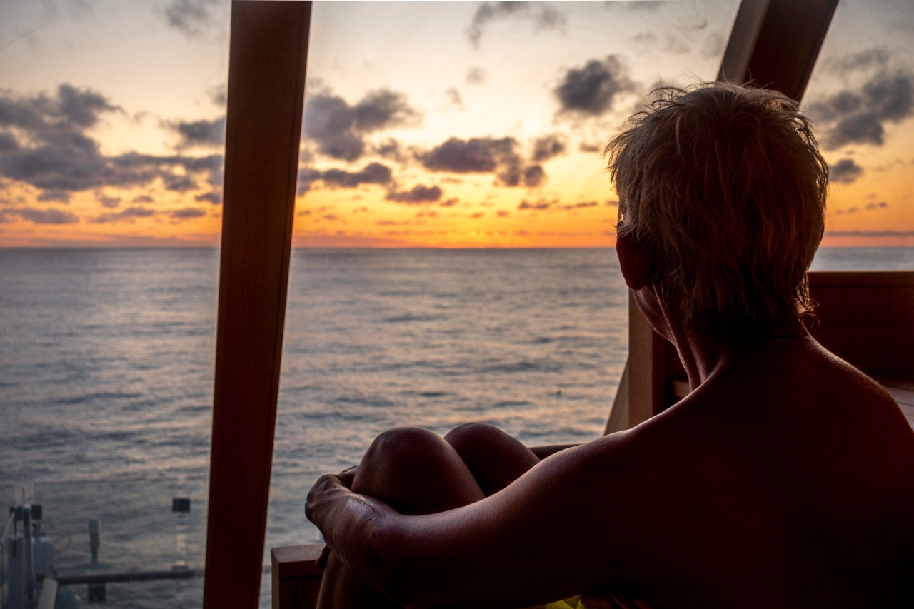 Eine „Mein Schiff“-Passagierin blickt auf das Meer hinaus.