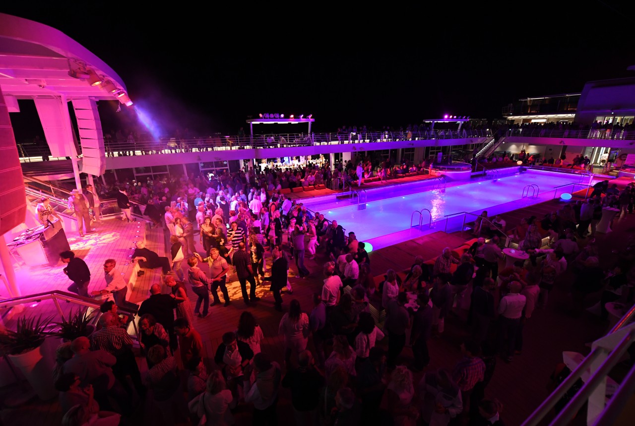 Passagiere amüsieren sich auf dem Pooldeck des Kreuzfahrtschiffs „Mein Schiff 3“ bei einer Poolparty (Archivfoto).