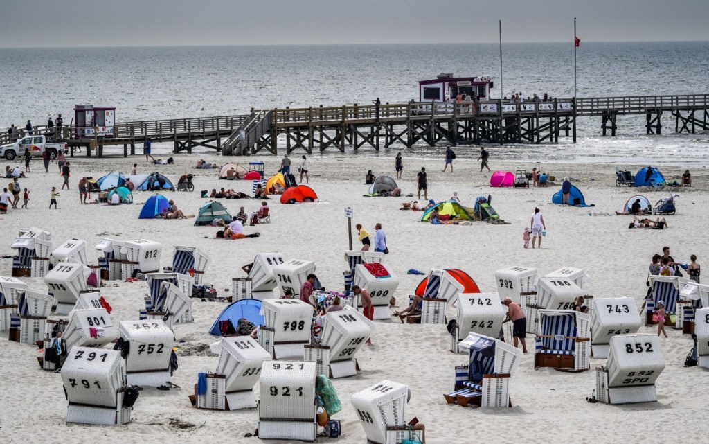 Der Strand von Sankt Peter-Ording ist so riesig, das Tausende Menschen dort Platz haben. Aber im Ort selbst zentriert sich das Urlaubsgeschehen., Unzählige Fahrräder sind von Touristen am Strand von Sankt Peter-Ording (SPO) an einem eigens für Zweiräder eingerichteten Parkplatz abgestellt.,