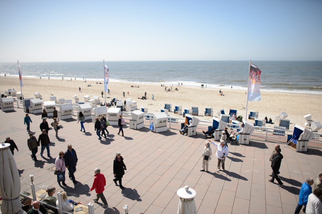 Zahlreiche Menschen gehen an der Strandpromende in Westerland auf Sylt entlang.