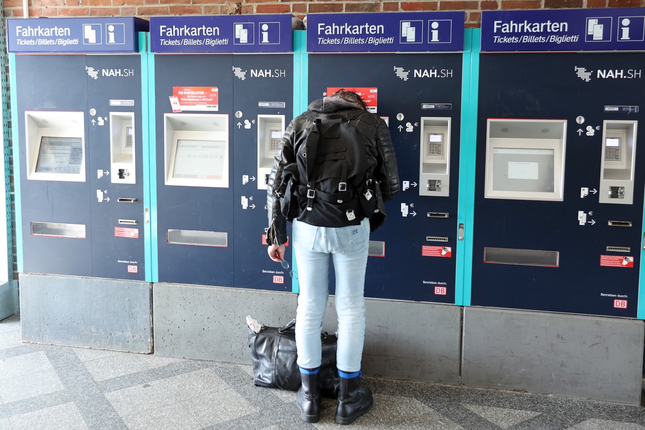 Ein Mann steht am Bahnhof Westerland auf Sylt an einem Fahrkartenautomaten. 
