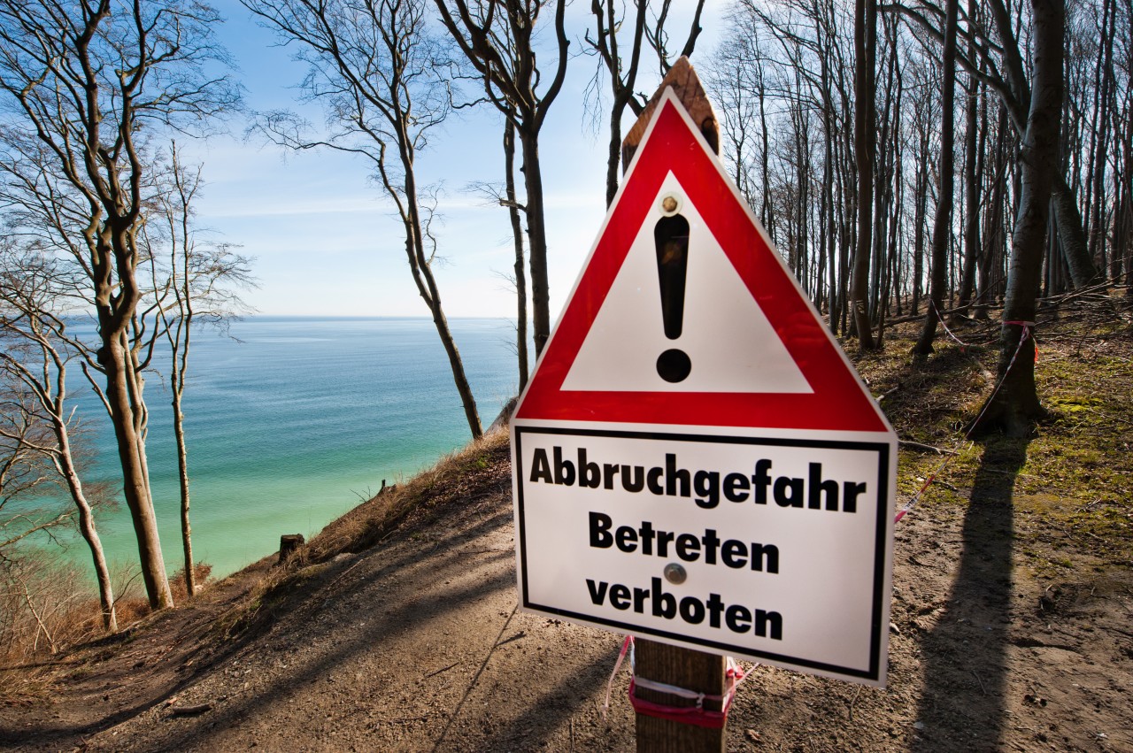 Ein Schild mit der Aufschrift „Abbruchgefahr Betreten verboten“ warnt an der Steilküste im Nationalpark Jasmund bei Sassnitz auf der Insel Rügen an der Ostsee.