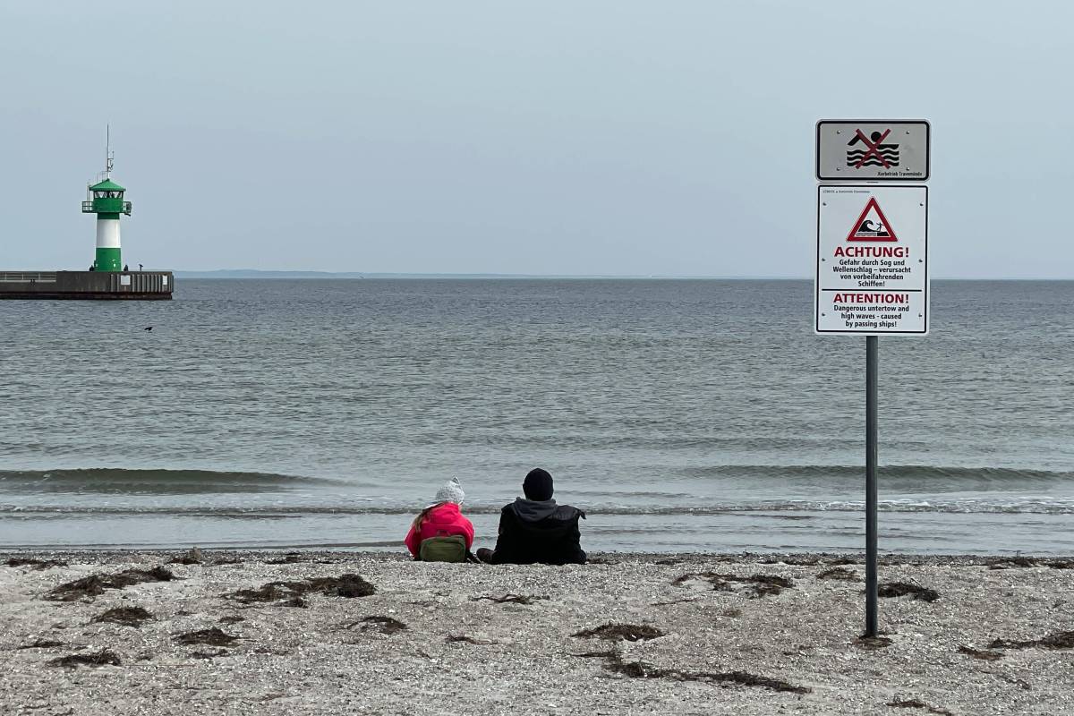 Menschen beobachten die Ostsee in Travemünde