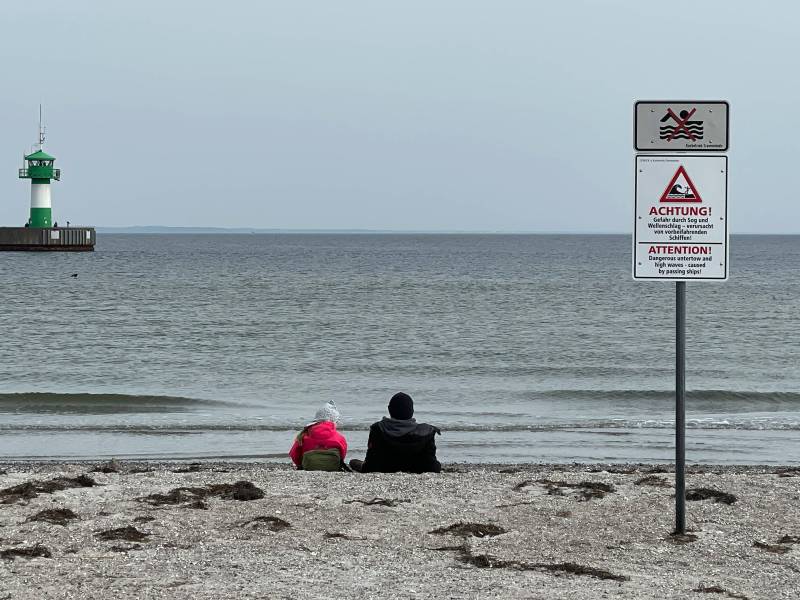 Menschen beobachten die Ostsee in Travemünde
