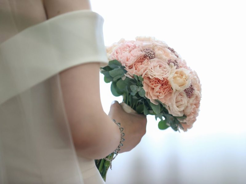 Hochzeit Braut in weißem Kleid und Blumenstrauß in der Hand
