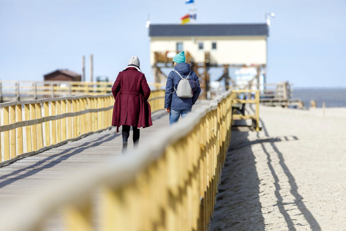 Urlauber auf der Seebrücke zum Sankt-Peter-Ording-Strand.
