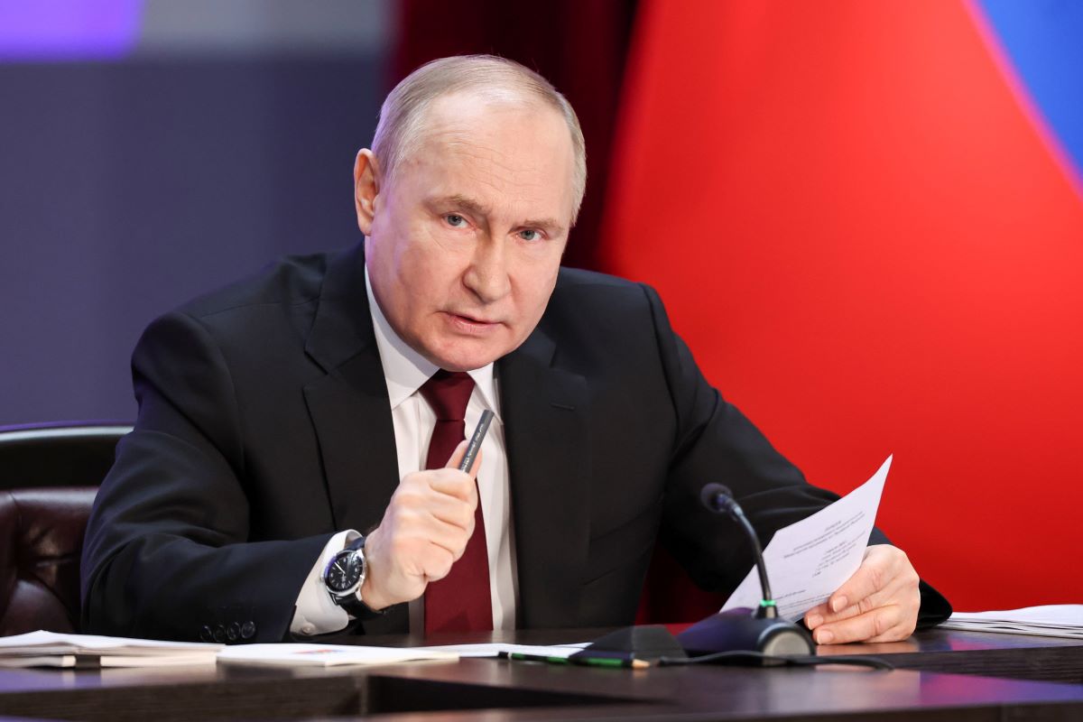 Russland-Präsident Wladimir Putin sitzt an einem Tisch, mit einem Zettel in der linken Hand.
