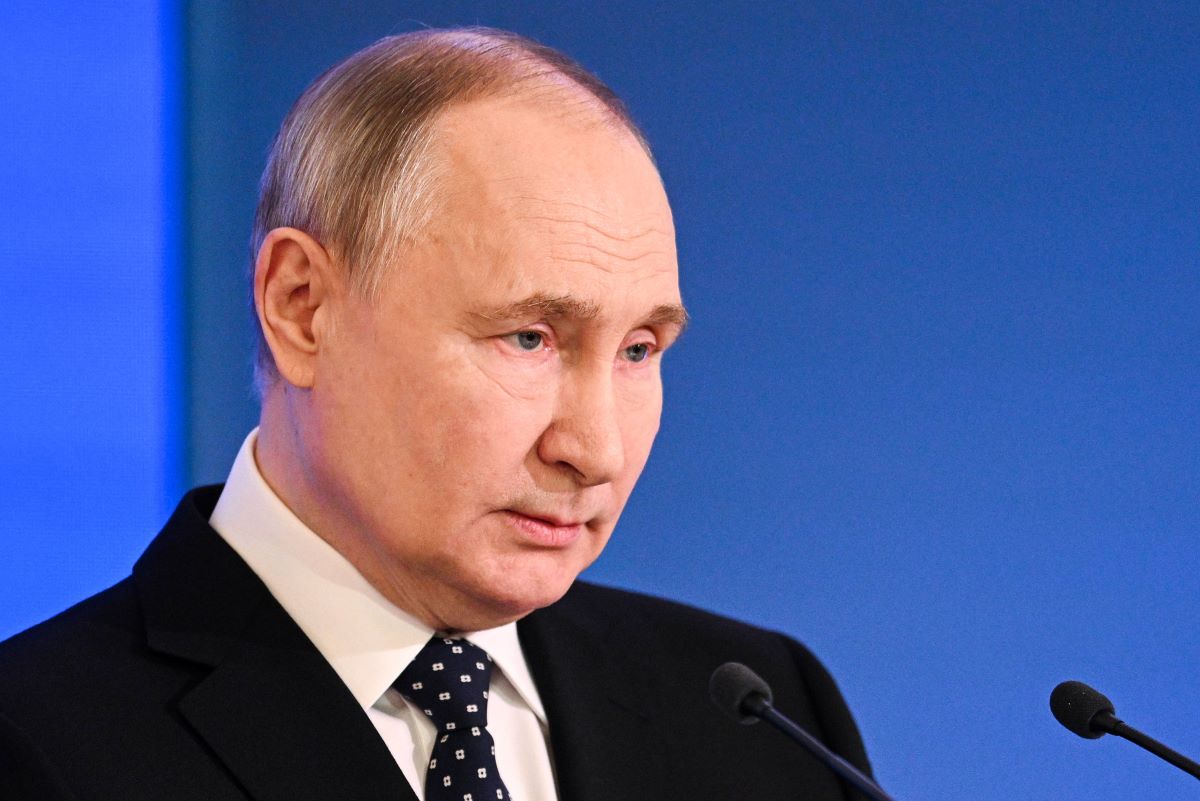 Wladimir Putin steht an einem Rednerpult.