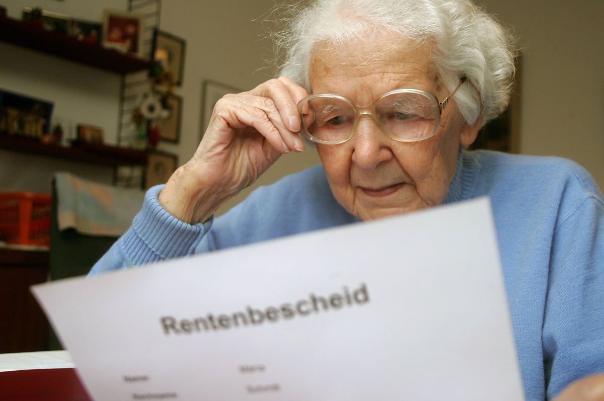 Eine ältere Frau bemustert ihren Rentenbescheid.
