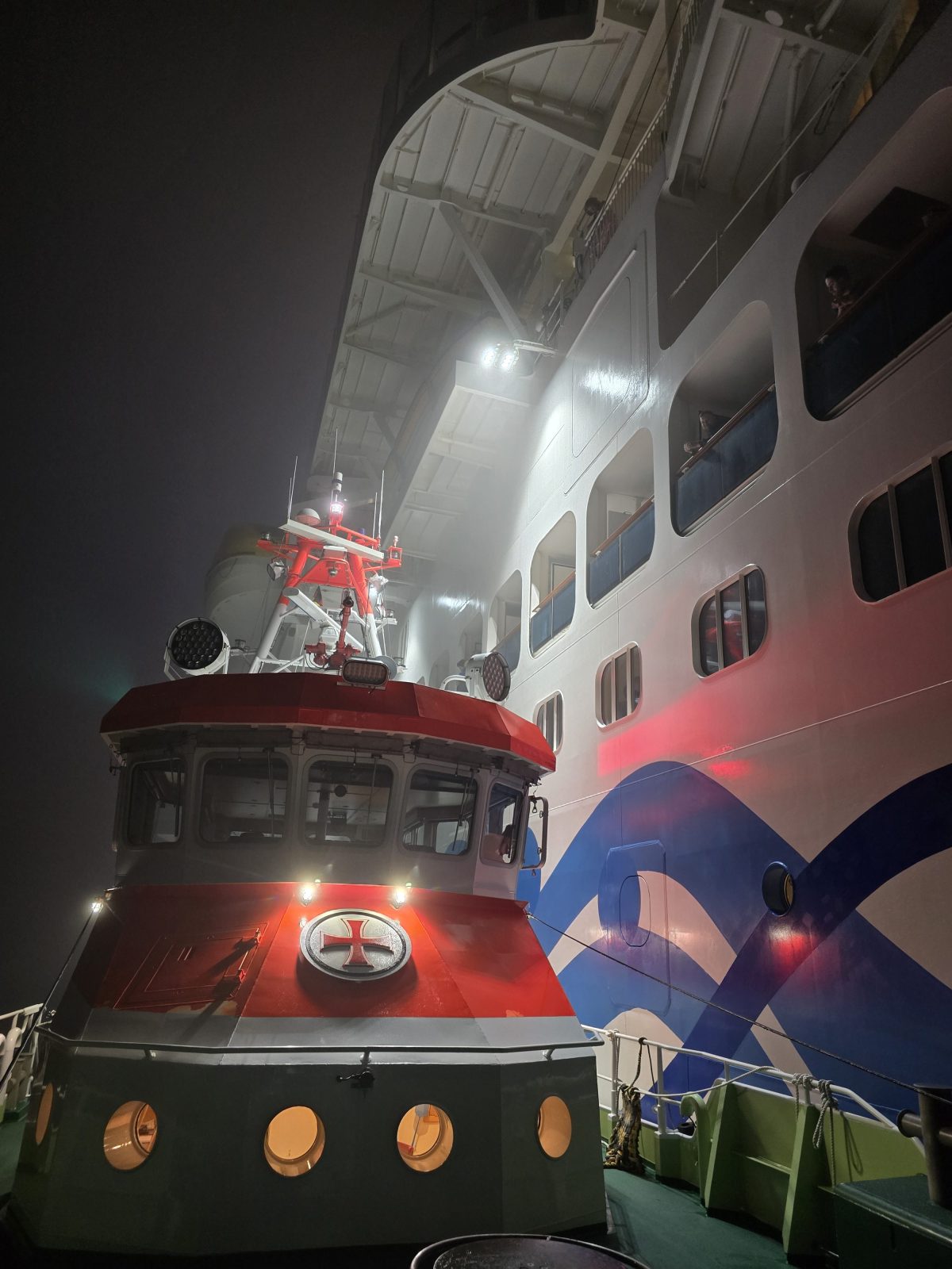 Der Seenotrettungskreuzer ANNELIESE KRAMER der DGzRS liegt längsseits des Kreuzfahrtschiffes „Aidanova“ und nimmt einen schwer erkrankten Passagier an Bord. Foto: Die Seenotretter