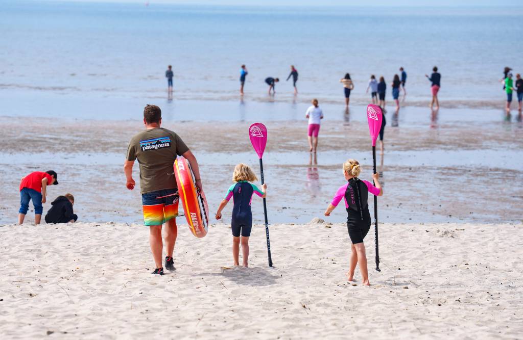 Kinder mit Paddel am Strand