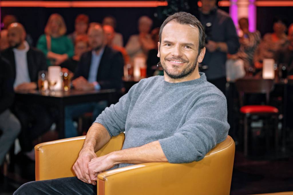 Steffen Henssler sitzt in einem gelben Sessel