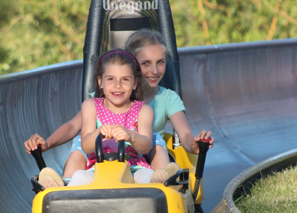 Kinder auf einer Sommerrodelbahn