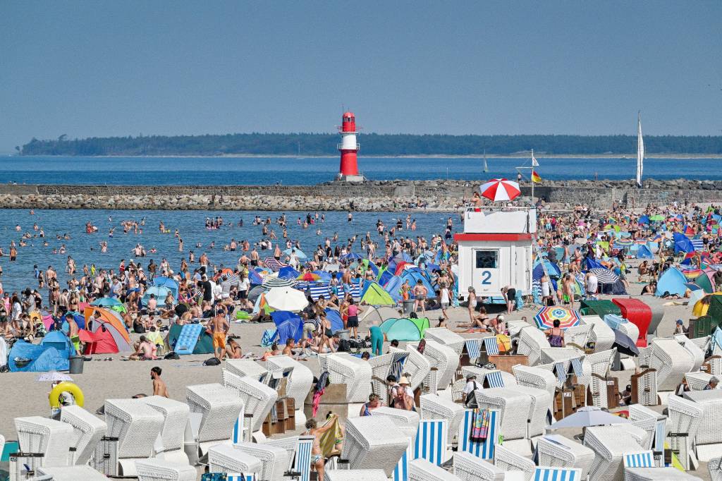 belebter Strandabschnitt mit Leuchtturm